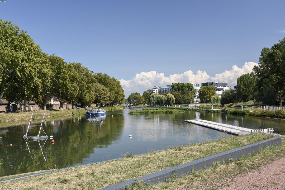 Piscine bordée de pierres devant une bastide périgourdine au soleil couchant